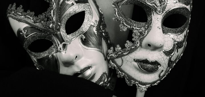 Dramatic black and white photo featuring an elegant woman holding two ornate Venetian masks.