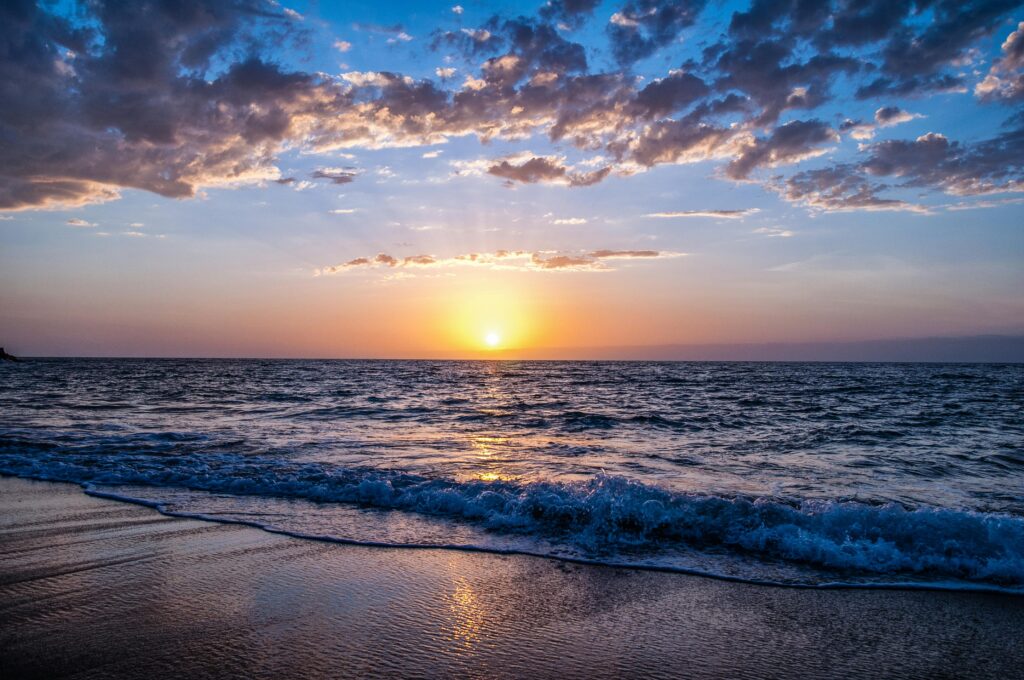 Captivating sunset over the ocean with vibrant colors, serene waves, and a peaceful sky.