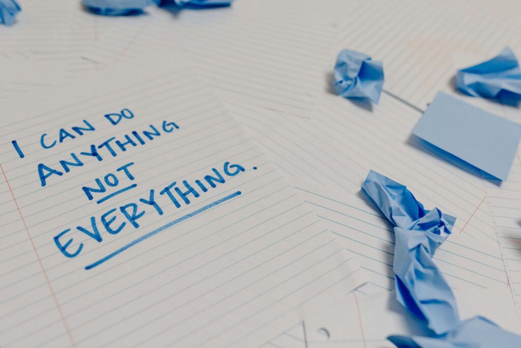 Motivational message on a page surrounded by crumpled papers and blue sticky notes.