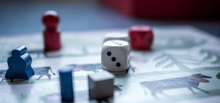 Close-up view of board game pieces and dice on a game board. Perfect for recreation and strategy themes.